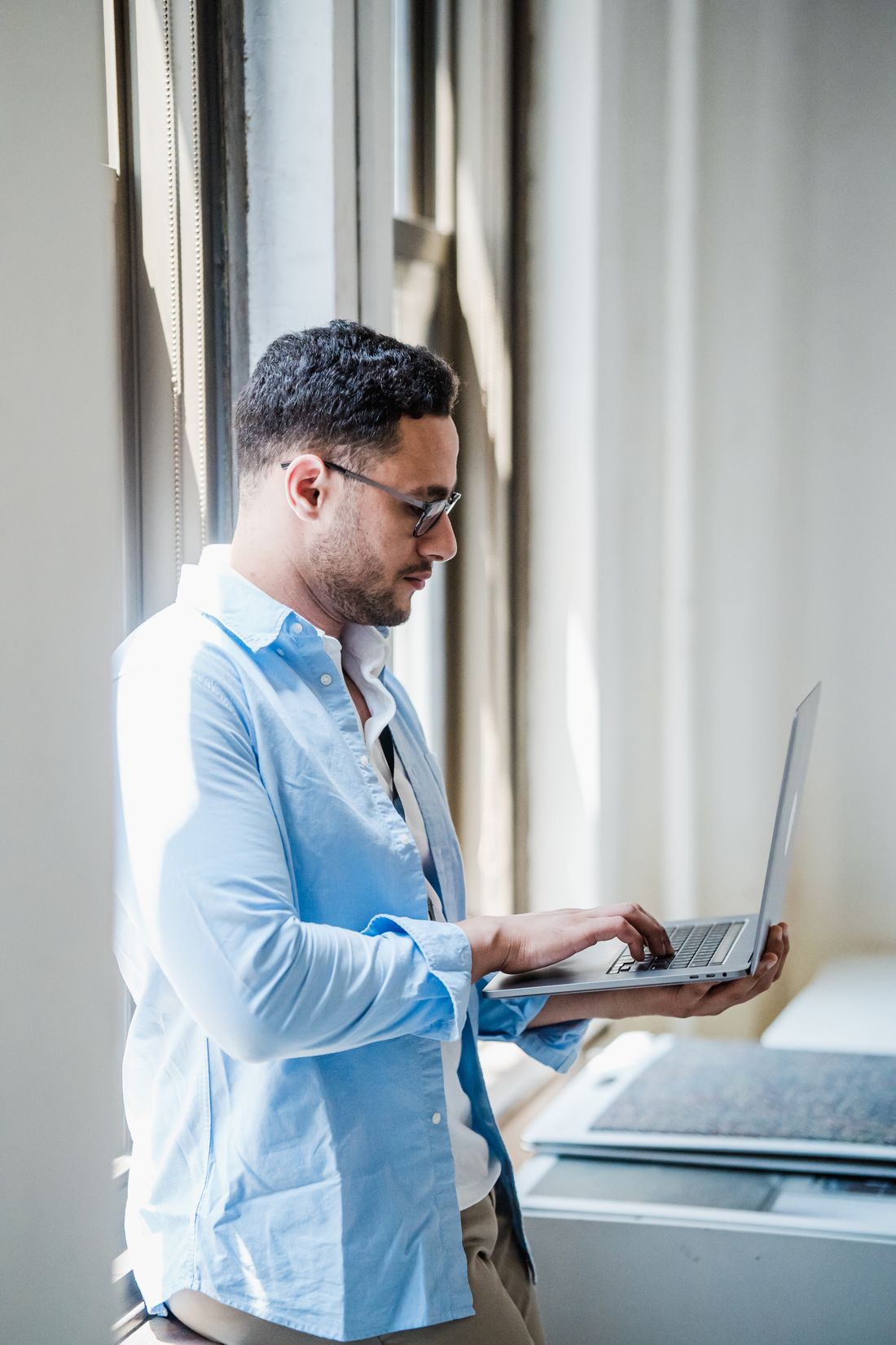 A founder working on a laptop by a bright window